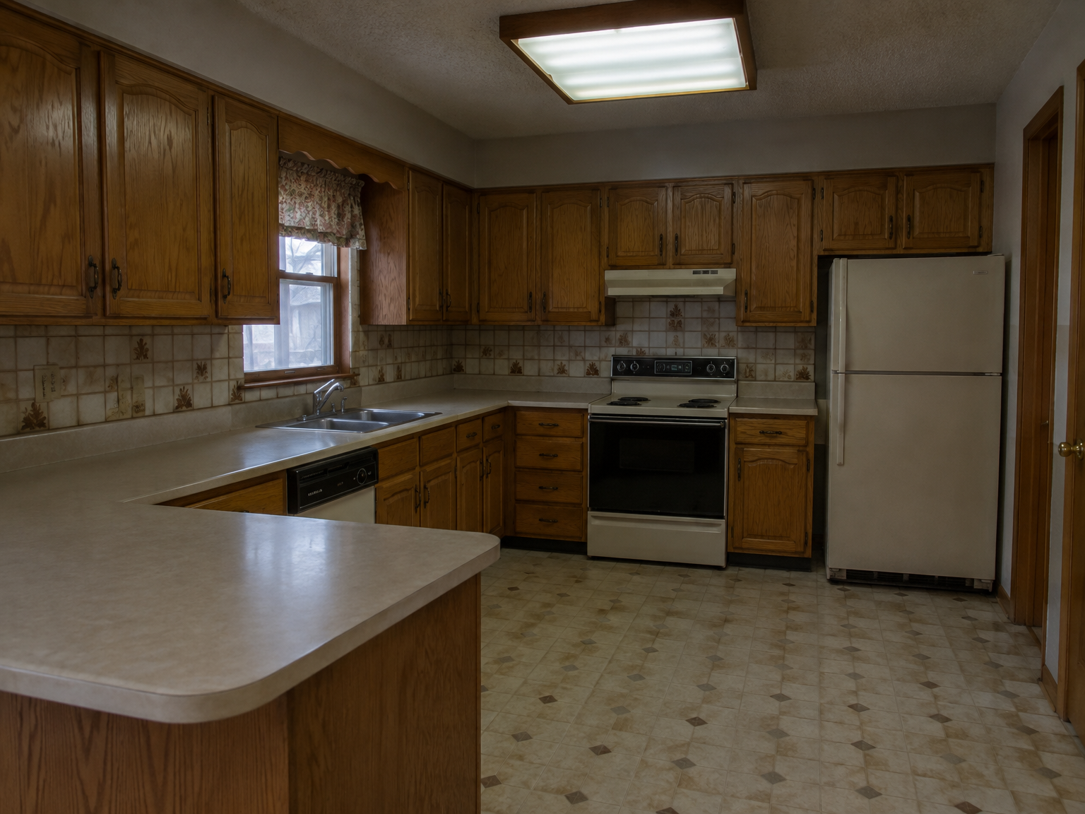 Dated 1990s kitchen with honey-oak cabinets and beige laminate counters