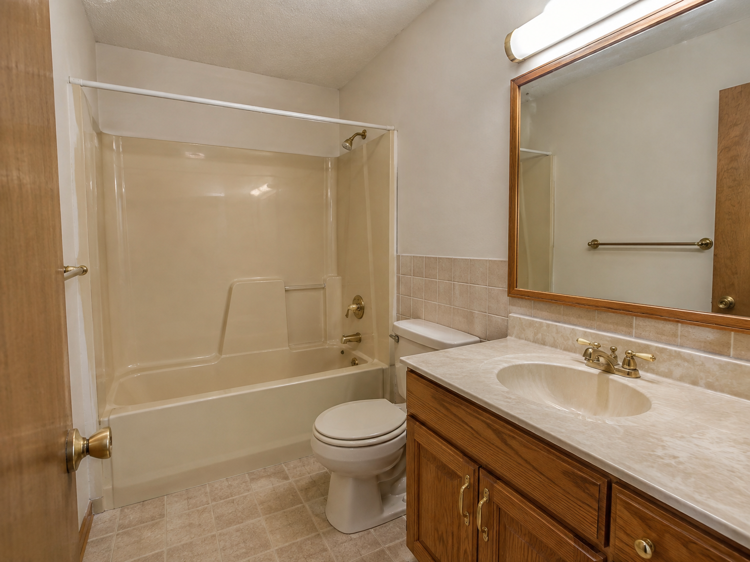 Dated 1990s bathroom with almond tub surround