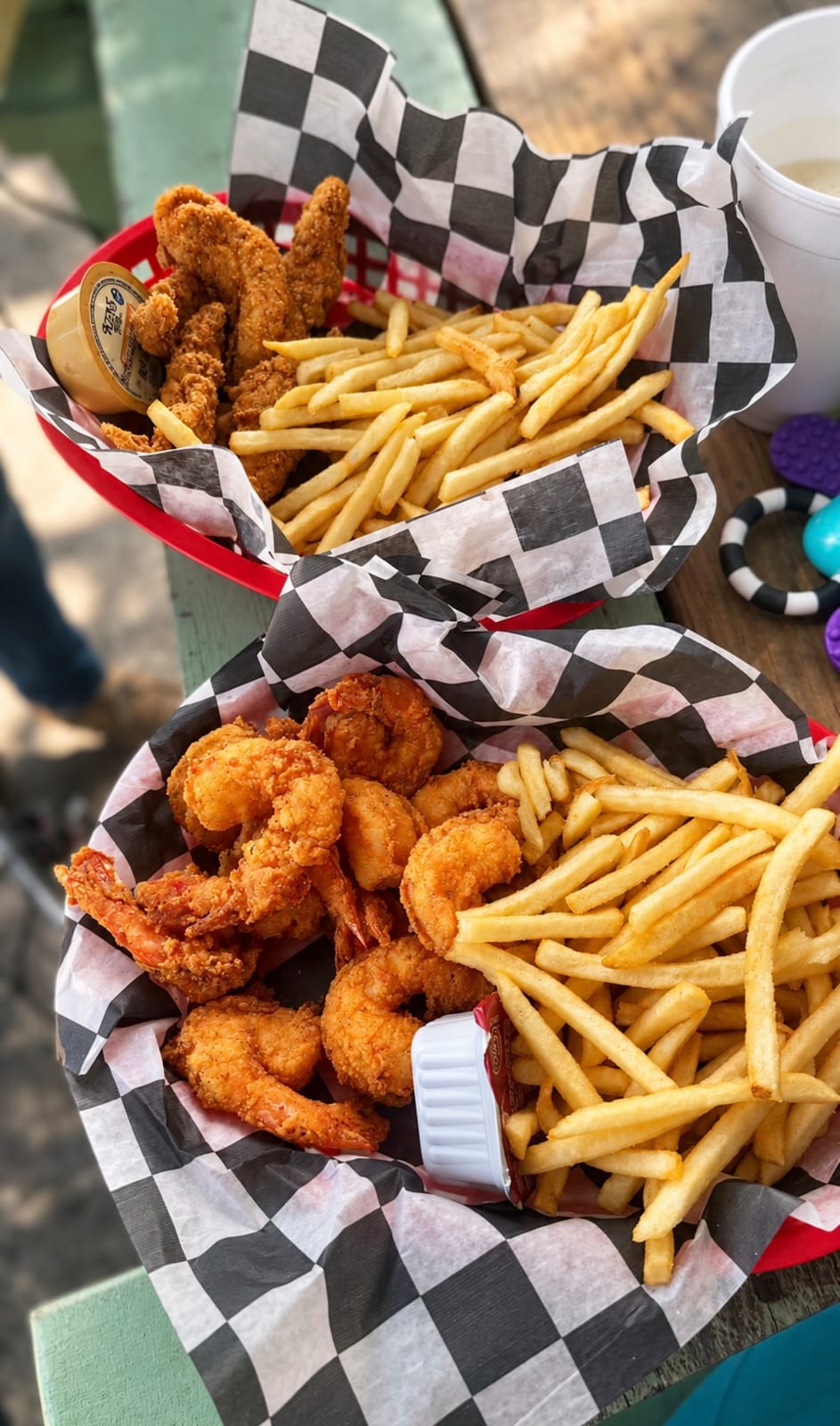 Fried shrimp basket and southern fried chicken tender basket with fries in checkered paper at Old Daufuskie Crab Company